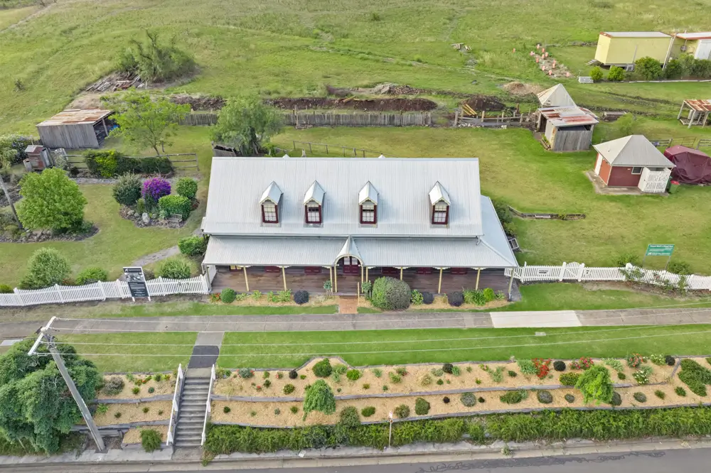 Aerial view of a country house with gardens and surrounding lawn.