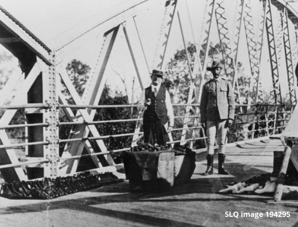 Two men standing on Queensland border bridge