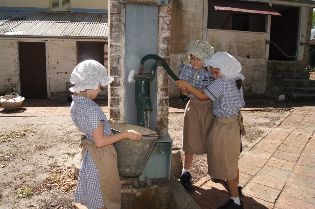 Children pumping water at National Trust Wolston Farmhouse