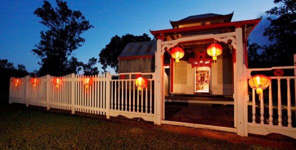 Traditional Chinese building with red lanterns at dusk.