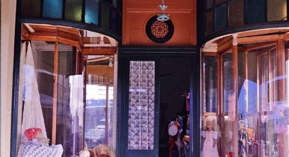 Vintage toy store with teddy bears and dolls on display.