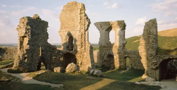 The medieval ruins of Corfe Castle at Dorset in the UK on a sunny, slightly misty day.